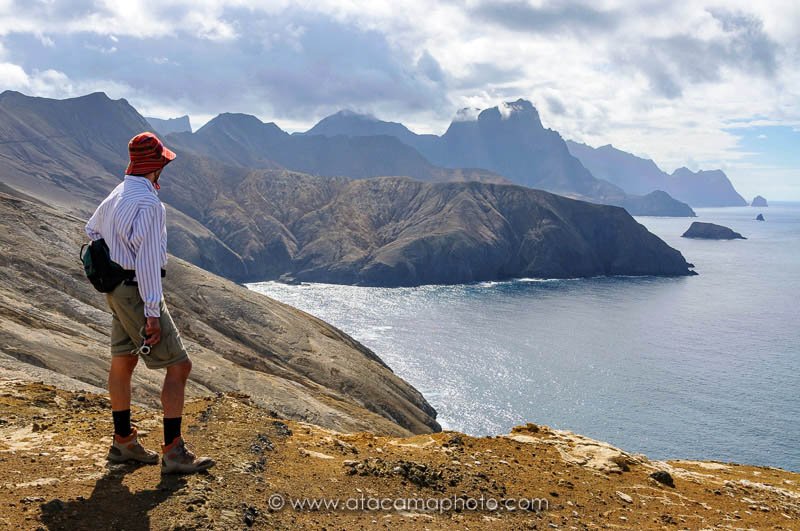 Tourist hiking at the rugged coast of Robinson Crusoe Island